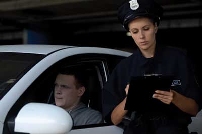 SLI - Female officer writing traffic ticket to male driver for parking violation, fine